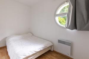 a small bedroom with a bed and a window at Villa Léonidas - Conciergerieland in Léon