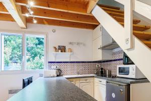 a kitchen with white cabinets and a counter top at Villa Léonidas - Conciergerieland in Léon