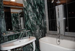 a bathroom with a sink and a tub and a toilet at Piena māja in Kukšas