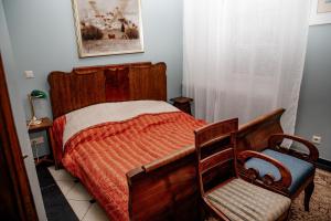 a bedroom with a wooden bed and a chair at Piena māja in Kukšas +5 photos