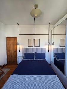 a bedroom with a large bed with blue pillows at Volpi Residence Savassi - VIP - Sinta-se em casa in Belo Horizonte +46 photos