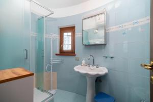 a blue bathroom with a sink and a shower at Autenticum Agriturismo Tolfa in Tolfa