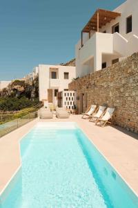 a swimming pool in front of a villa at ANDELIAS Signature Suites in Chora Folegandros