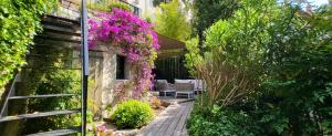 a garden with pink flowers on the side of a building at Villa Le Loft by Festif Azur 4-Star 200m2 House with Garden, 5-Min Walk to Palais des Festivals and Beaches in Cannes