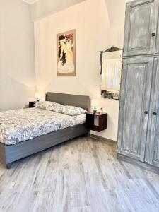 a bedroom with a bed and a wooden floor at Casa Ferro in Finale Ligure