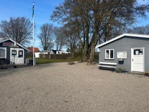 a small building next to a building with a flag at Stege Camping in Stege