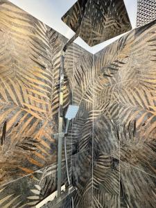a bathroom with a shower with a mural of palm leaves at Casa Ferro in Finale Ligure