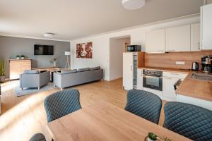 a kitchen and living room with a table and chairs at Ferienwohnung Riethchaussee in Wingerode