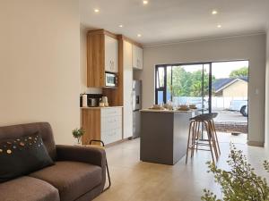 a kitchen and living room with a couch and a counter at Executive Suites Brackenhurst in Alberton