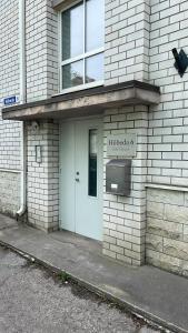 a white brick building with a door and a sign on it at Hobeda 6 Guest House in Tallinn