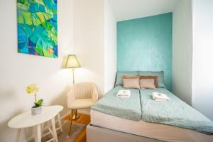 a small bedroom with a bed and a chair at Amada Apartment in Budapest