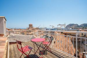a deck with chairs and a table on a balcony at Joli Cocon - Meublé de tourisme classé 2 étoiles - Terrasse - Parking in La Ciotat