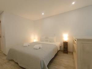 a bedroom with a bed with two pillows on it at Tomarhousing - Secret Garden in Tomar
