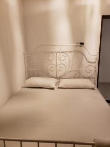 a white bed with two pillows on top of it at Amantha Holiday Resort in Anuradhapura