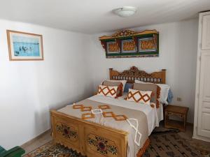 a bedroom with a bed with a wooden headboard at Studio Traditionnel a louer-Mahdia in Mahdia