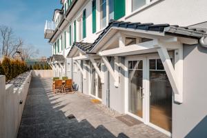 a building with white doors and chairs on a sidewalk at Ferienwohnung Riethchaussee in Wingerode