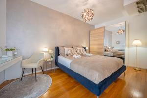 a bedroom with a bed with a chair and a mirror at Amada Apartment in Budapest