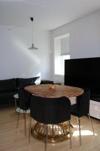 a dining room with a wooden table and black chairs at Aurora Studio Apartments in Nuuk +3 photos