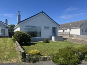 a white house with a yard at Mor Annedd Cymyran in Valley