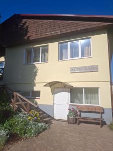 a house with a bench in front of it at Apartmenti Ezerkrasti in Jaunpils