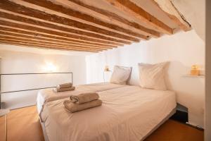 a bedroom with a white bed with two towels on it at Joli Cocon - Meublé de tourisme classé 2 étoiles - Terrasse - Parking in La Ciotat