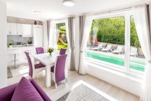 a living room with a table and chairs and a large window at Planinska Oaza in Pale