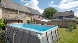 a swimming pool in the yard of a house at Gîte Le Relais De Jehan in Saint-Malo des 3 Fontaines