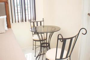 a glass table and two chairs in a room at The Vista Inn Studio #2 in Falmouth +1 photo
