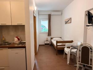 a small room with a kitchen and a bed at Apartments Tomislav in Vodice