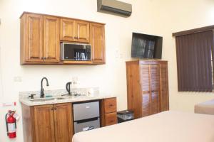 a kitchen with wooden cabinets and a sink and a microwave at The Vista Inn Studio #2 in Falmouth