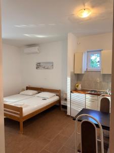 a small room with a bed and a kitchen at Apartments Tomislav in Vodice