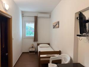 a small room with a small bed and a window at Apartments Tomislav in Vodice