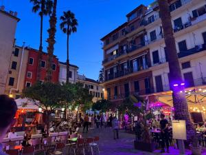 a group of people walking around a street at night at Via Corradi in Sanremo