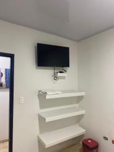 a flat screen tv on a white wall at Hotel Nella Mar in Puerto Colombia