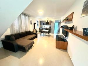 a living room with a couch and a dining room at Maver apartment in Mali Lošinj +16 photos