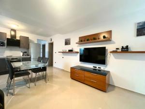 a living room with a television and a dining table at Maver apartment in Mali Lošinj