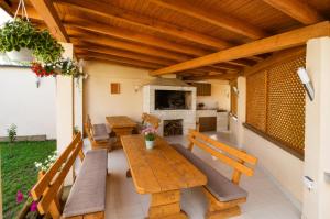 a patio with wooden tables and benches and a fireplace at Planinska Oaza in Pale
