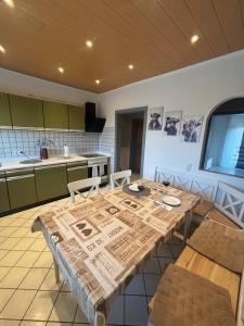 a kitchen with a wooden table with chairs at Ferienwohnung Habichtweg in Elsdorf