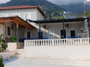 a white house with a balcony with mountains in the background at Joanna hause in Gjilek