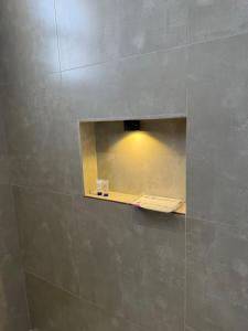 a bathroom with a mirror and a light on the wall at شقة مودرن غرفة وصالة in Buraydah +4 photos
