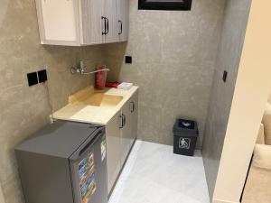 a small kitchen with a sink and a refrigerator at شقة مودرن غرفة وصالة in Buraydah