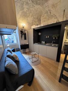 a living room with a blue couch and a kitchen at Via Corradi in Sanremo