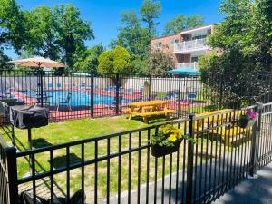a fence with chairs and tables and a pool at Comfortable 2BR Office Setup in Elkins Park