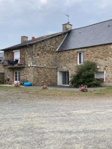 a brick house with flowers in front of it at Sci Licorne d Or in Saint-Méloir-des-Ondes