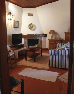 a living room with a couch and a fireplace at Casa Nova da Corte Salva in Grândola