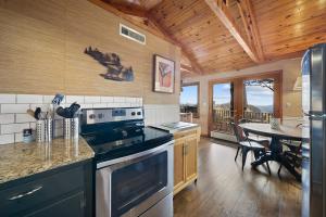 a kitchen with a stove and a dining room with a table at Blowing Rock Skies in Lenoir