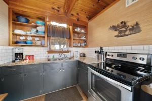 a kitchen with gray cabinets and a stove at Blowing Rock Skies in Lenoir