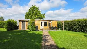 a small cabin in a garden with a grass yard at Tinyhouse op de Veluwe, het buitenleven in Oene