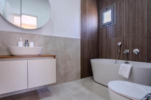 a bathroom with a white tub and a sink at Kaura Villas in Milas +15 photos