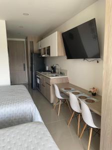 a bedroom with a bed and a kitchen with a table and chairs at Exclusive Rodadero Sur Studio Apartment in Santa Marta